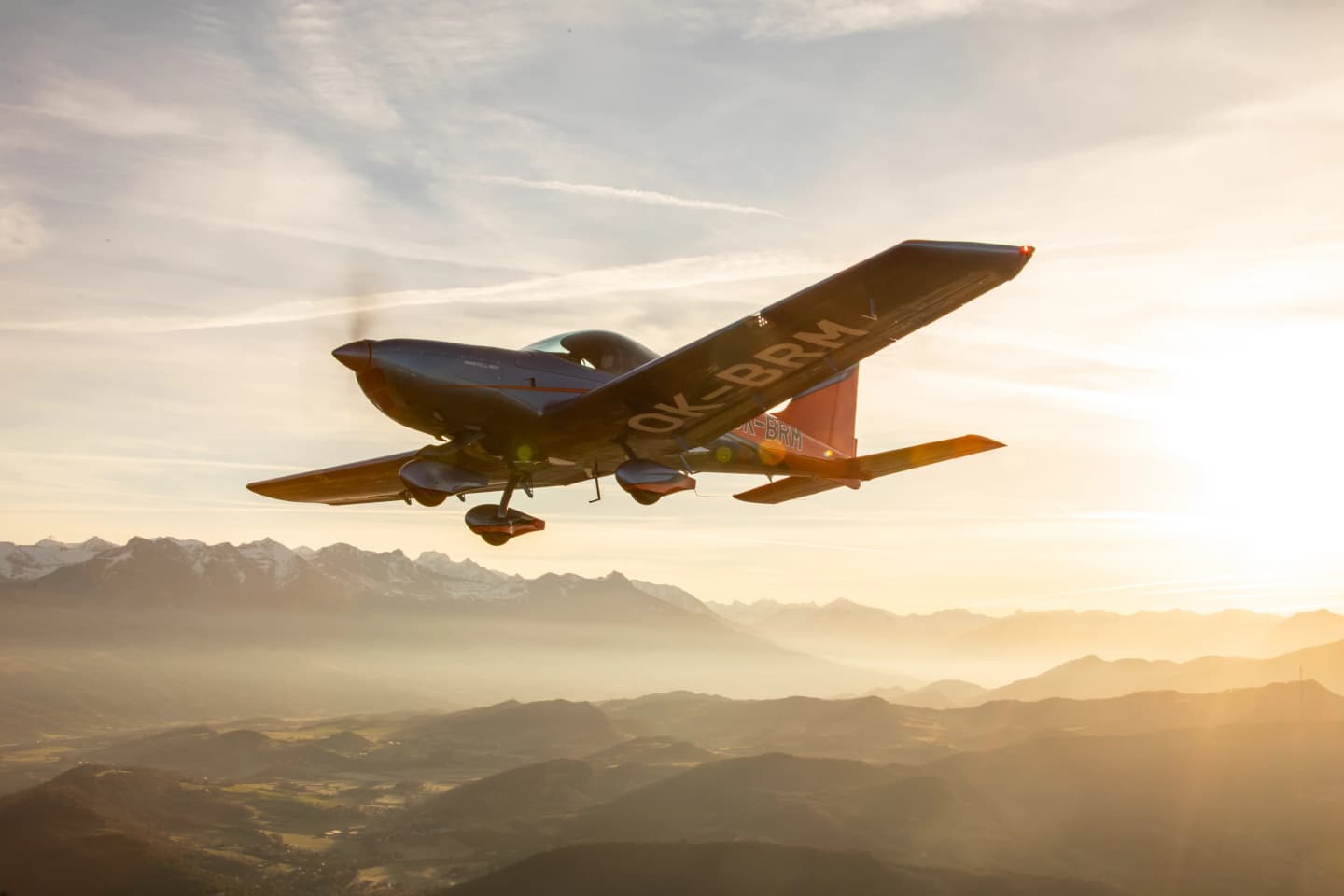 Bristell B23 climbing at golden hour above misty mountain ridges