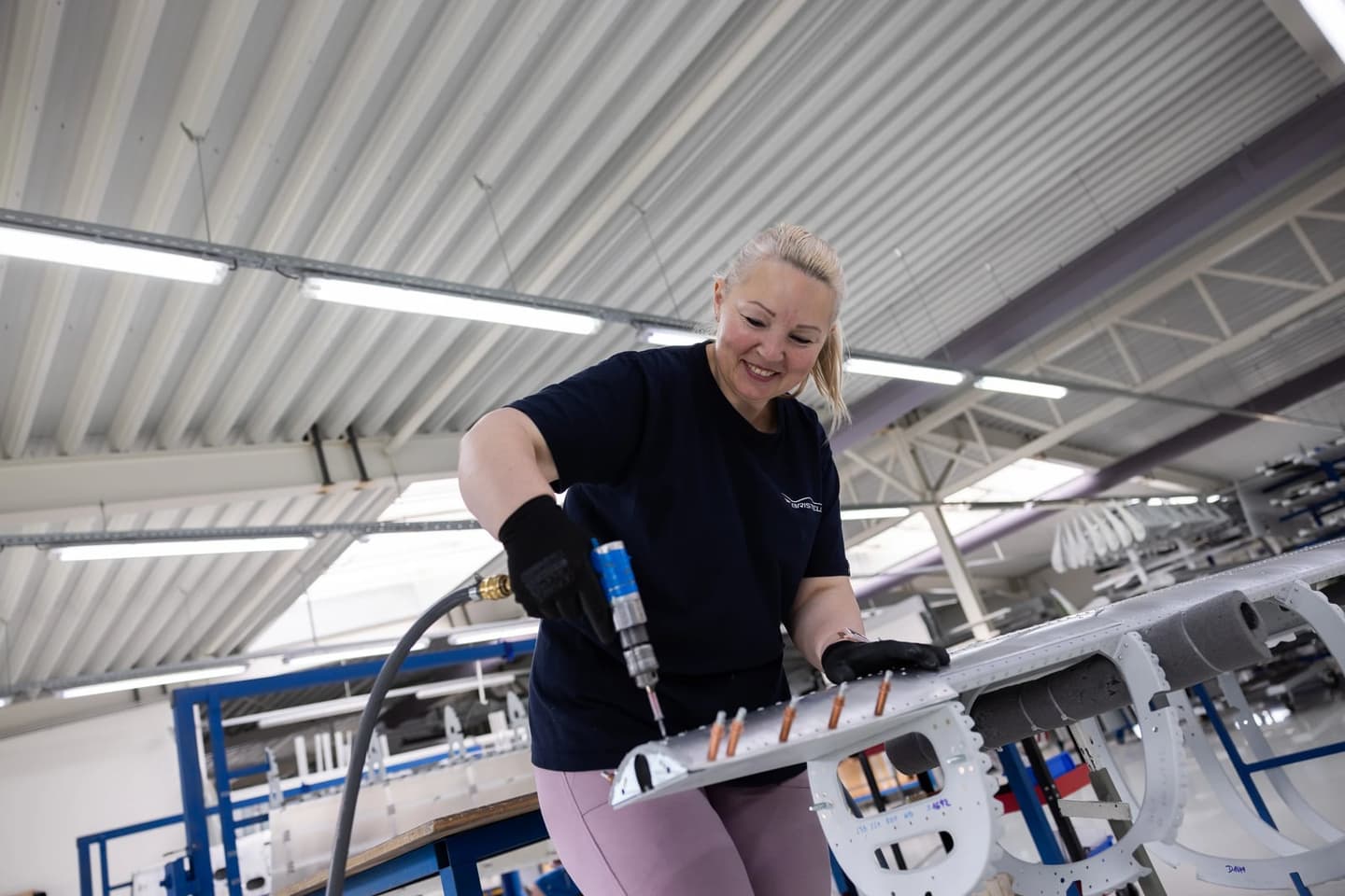 A BRM AERO technician using a pneumatic tool on an all-metal airframe sub-assembly on the production line