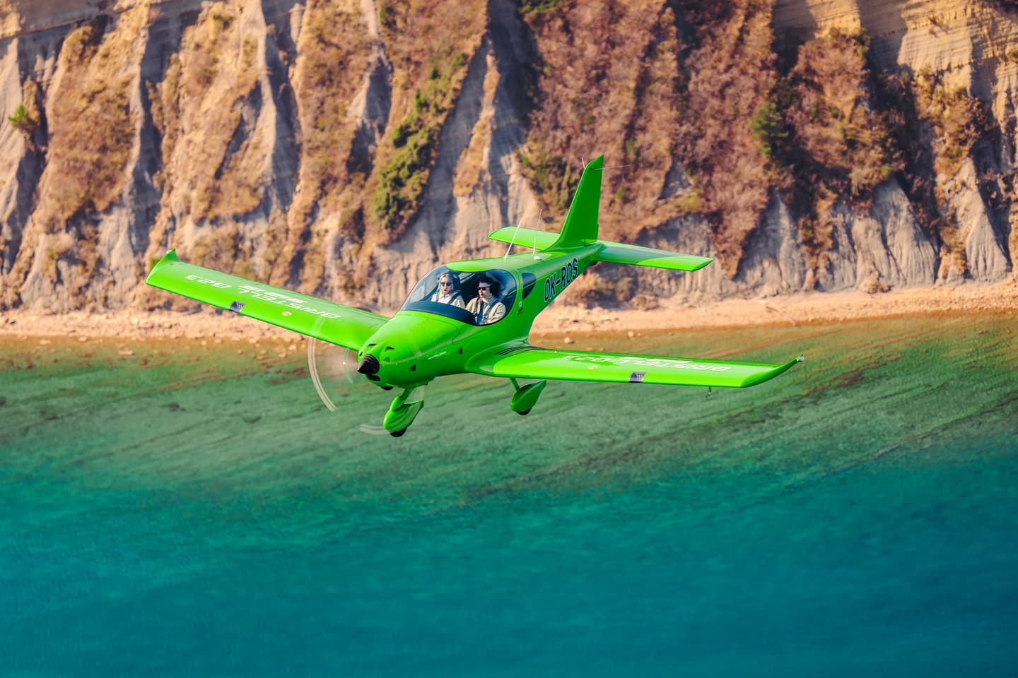 A Bristell B23 light aircraft in flight over a coastline