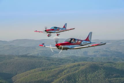 Two Bristell UL/LSA aircraft flying in formation over the countryside