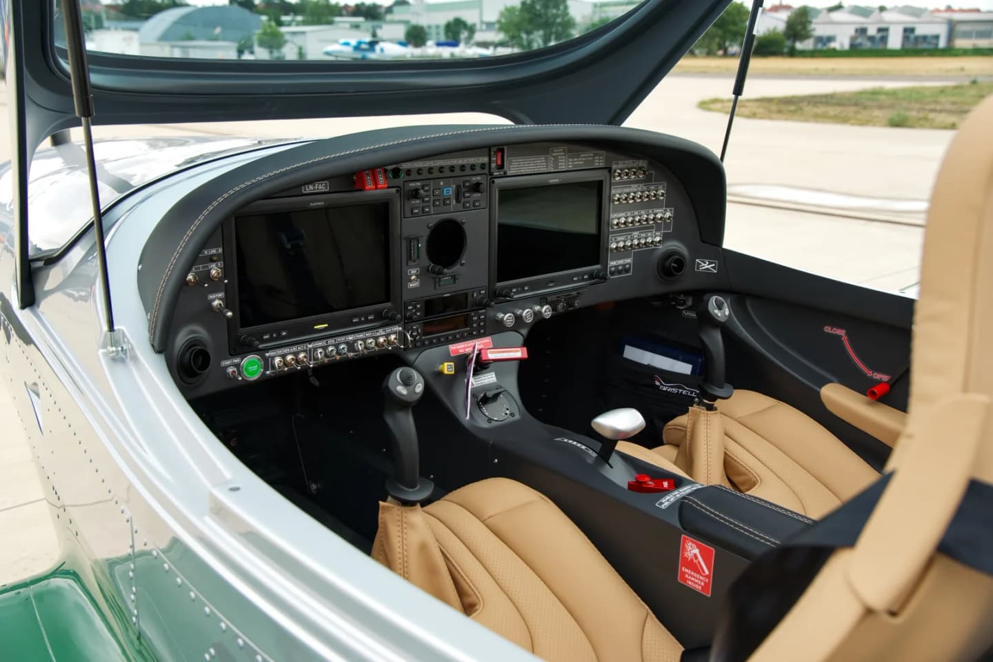Bristell B23 cockpit with two Garmin glass displays, a single power lever and tan leather seats, the LN-FAC registration placard on the glareshield