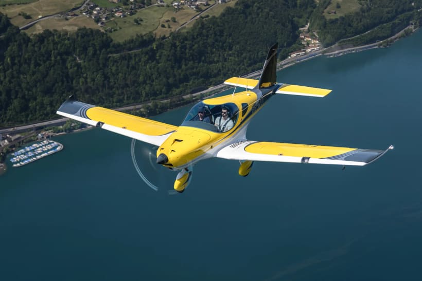 Bristell B23M in flight over a lake